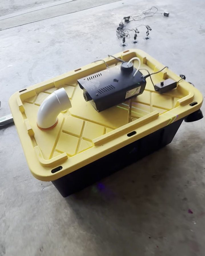Fog machine sitting on the yellow lid, aimed at the white elbow