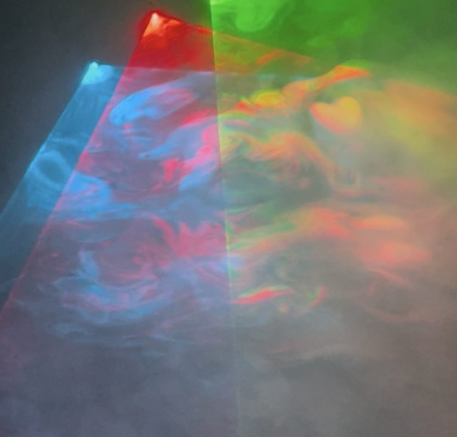 Fog swirls inside colored laser beams