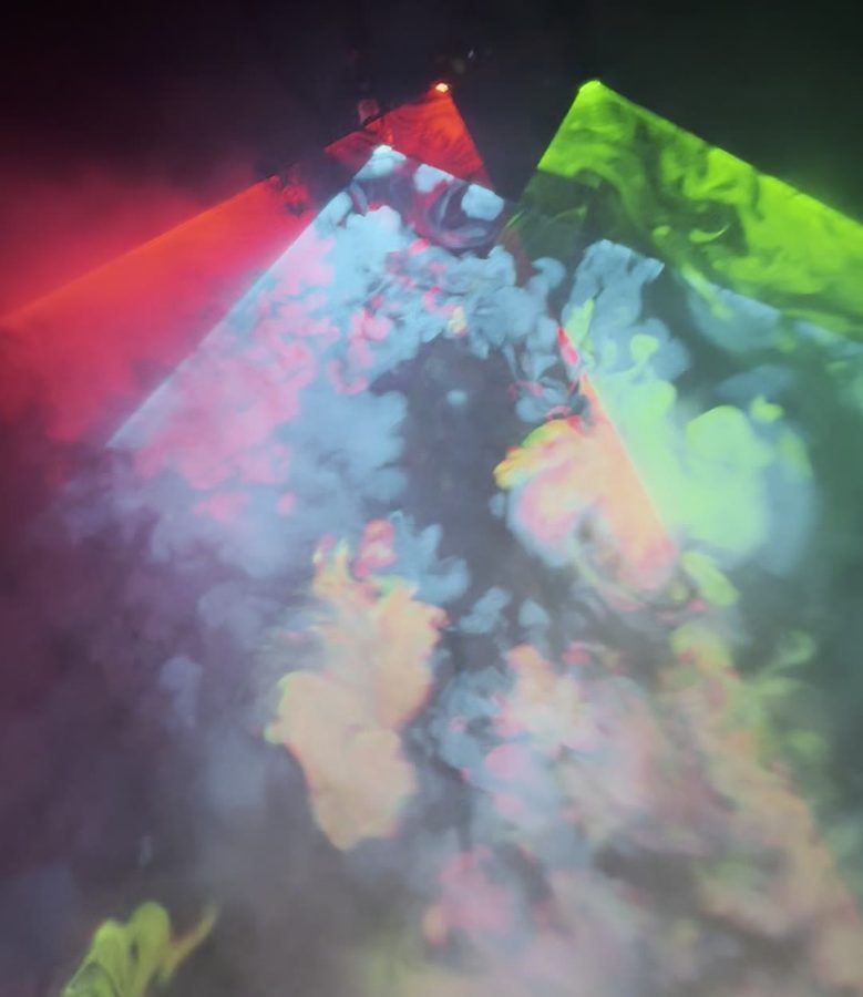 Three laser fans spreading over billowing fog at night