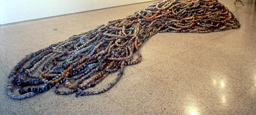 Mound of thick wrapped rope flowing across a terrazzo gallery floor.