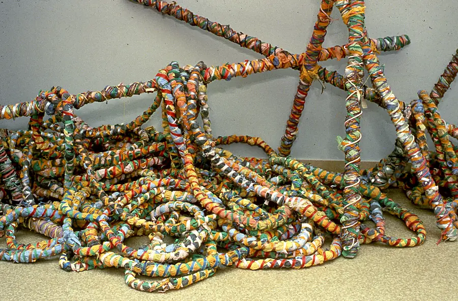 Close-up of rope and poles wrapped in strips of printed and solid fabric.