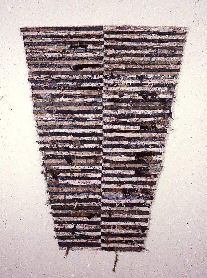 Tall tapering wall piece of horizontal strips in black, navy and white-pink divided by a vertical seam.